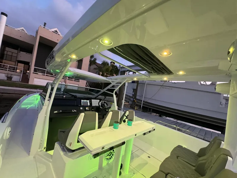 Slide: The Image of 2021 Axopar 37ST boat interior with seating and table, docked at marina. - 43