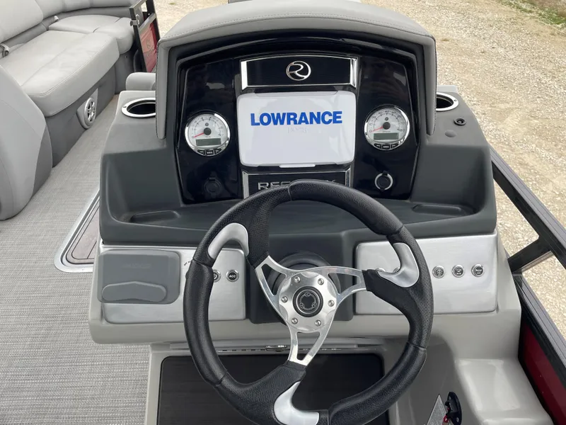 Slide: The Image of 2023 Regency 250 DL3 boat dashboard with Lowrance display and steering wheel. - 12