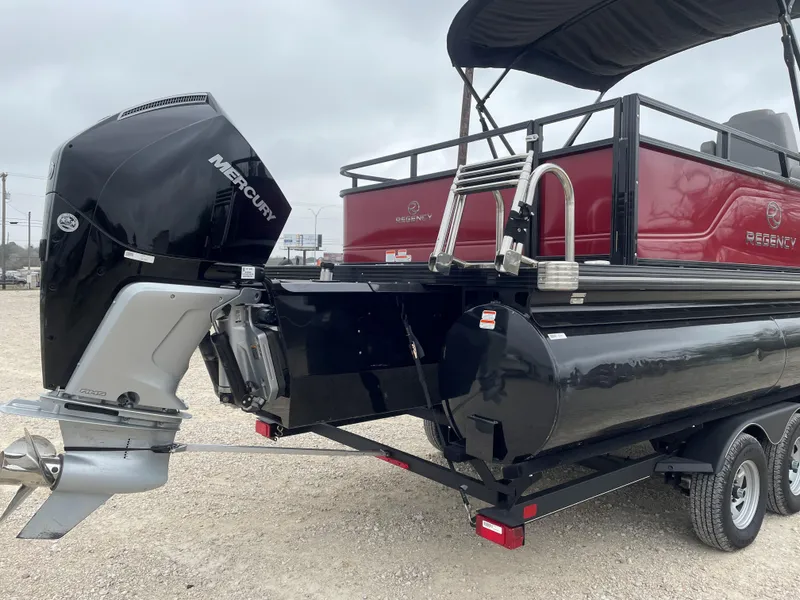 Slide: The Image of 2023 Regency 250 DL3 pontoon boat with Mercury outboard motor, black and red design. - 5