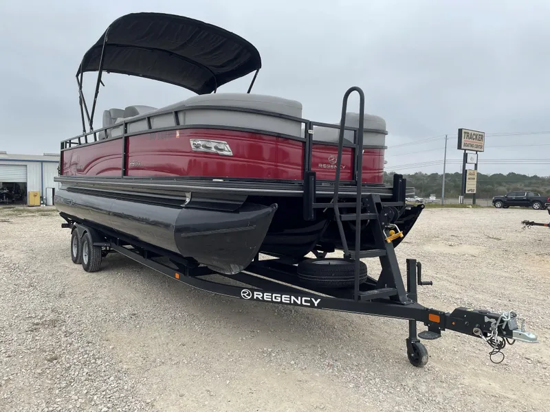 Slide: The Image of 2023 Regency 250 DL3 pontoon boat on trailer, red exterior, black canopy. - 7