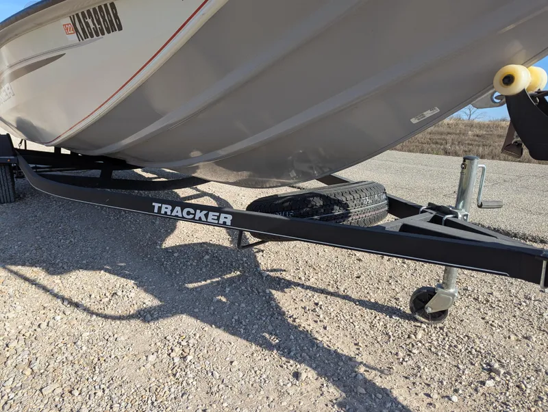 Slide: The Image of 2019 Tracker Pro Team 195 TXW Tournament Edition boat on trailer, parked on gravel. - 10