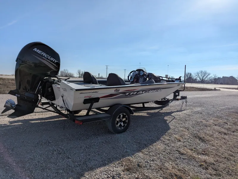 Slide: The Image of 2019 Tracker Pro Team 195 TXW Tournament Edition boat on a trailer, parked outdoors. - 7