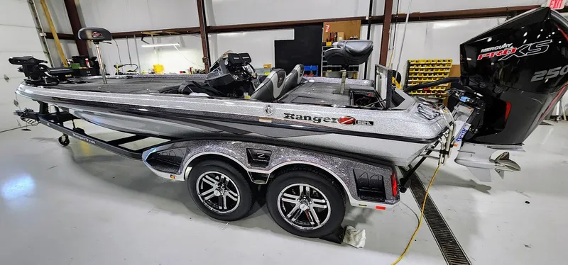 Slide: The Image of 2019 Ranger Z521L bass boat in a garage, featuring a powerful outboard motor. - 12