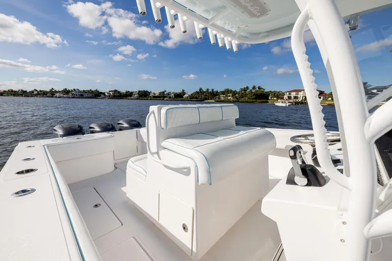 Slide: The Image of 2018 SeaHunter 33' Center Console boat on calm water, featuring sleek white seating and controls. - 15