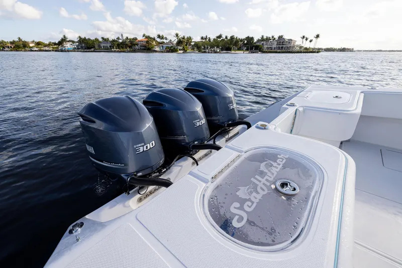 Slide: The Image of 2018 SeaHunter 33' Center Console with triple 300 horsepower engines on calm water. - 20