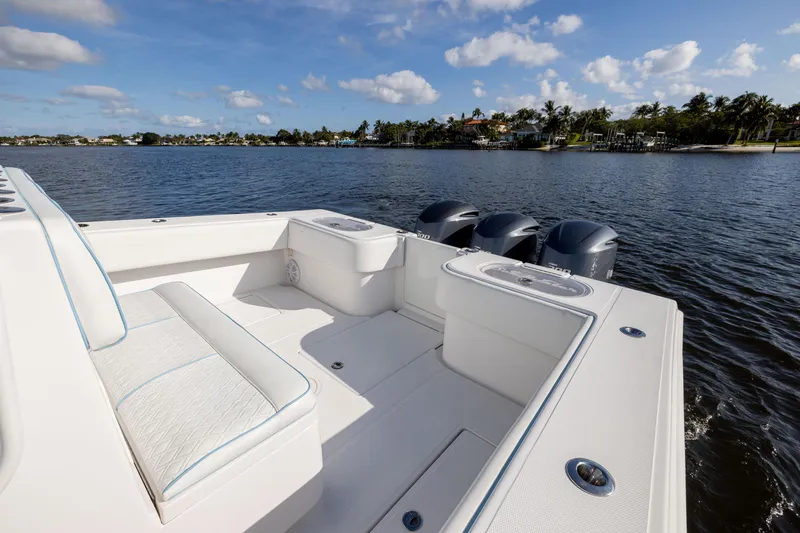 Slide: The Image of 2018 SeaHunter 33' Center Console boat on calm water, featuring spacious seating and triple engines. - 3