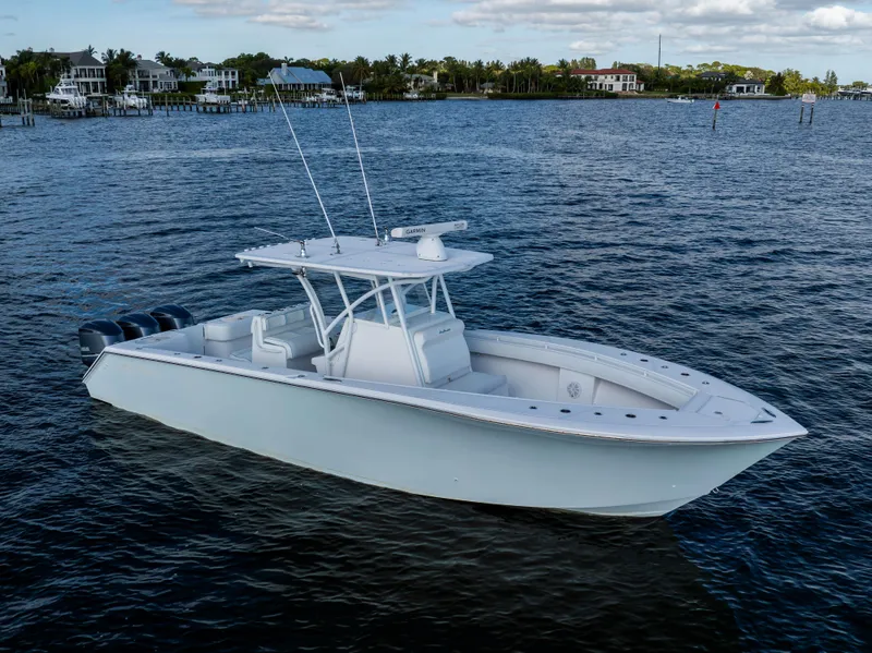 Slide: The Image of 2018 SeaHunter 33' Center Console boat on calm water, coastal background. - 37