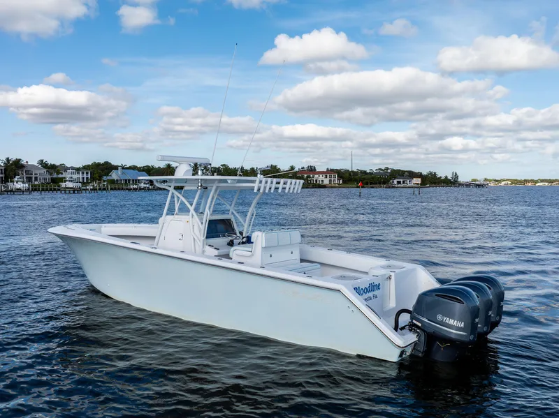 Slide: The Image of 2018 SeaHunter 33' Center Console boat on calm water, featuring twin Yamaha engines. - 39