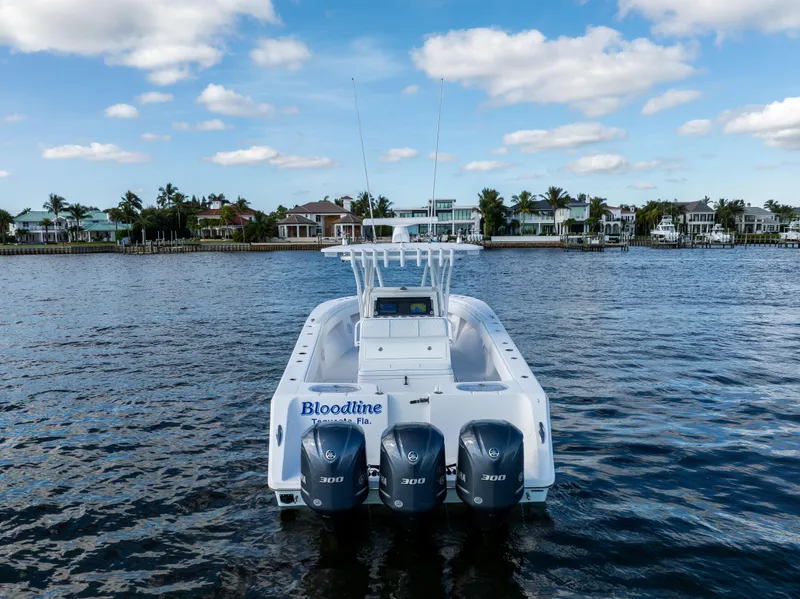 Slide: The Image of 2018 SeaHunter 33' Center Console boat with triple engines on a calm waterway. - 40