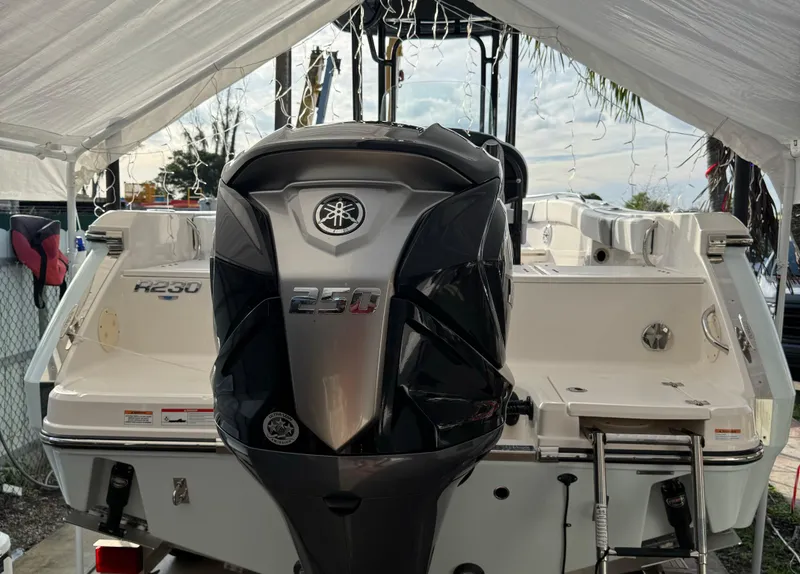 Slide: The Image of 2022 Robalo R230 Center Console boat with powerful outboard motor under a canopy. - 4