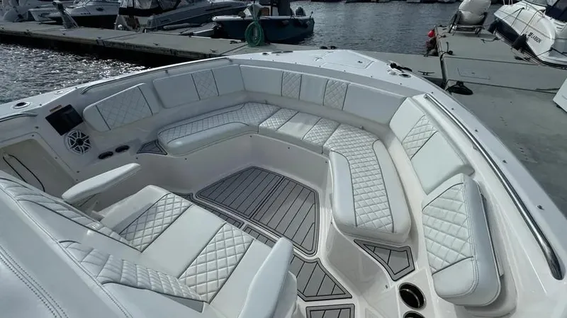 Slide: The Image of 2022 Pursuit S 358 Sport boat with luxurious white seating at a marina. - 10