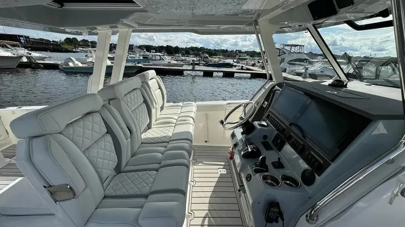 Slide: The Image of 2022 Pursuit S 358 Sport boat interior with luxurious seating and modern dashboard. - 12