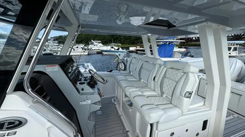 Slide: The Image of 2022 Pursuit S 358 Sport boat interior with luxurious seating and modern controls. - 13