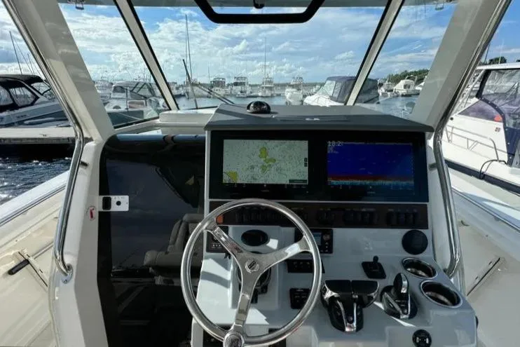 Slide: The Image of 2022 Pursuit S 358 Sport boat dashboard with navigation screens and steering wheel. - 14