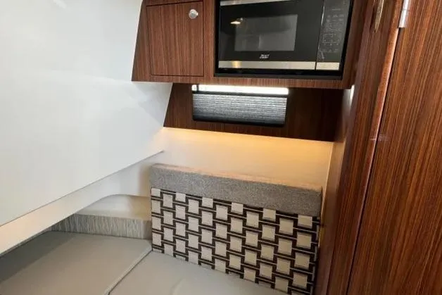 Slide: The Image of 2022 Pursuit S 358 Sport cabin interior with microwave and modern wood cabinetry. - 18