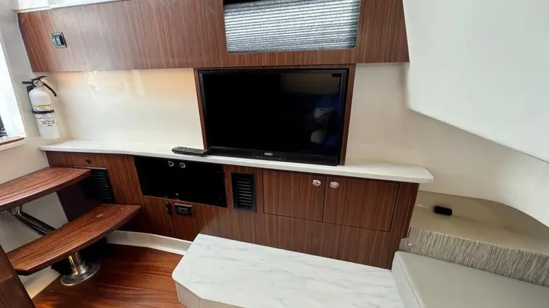 Slide: The Image of Interior of 2022 Pursuit S 358 Sport boat with TV and wooden cabinetry. - 19