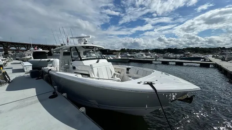 Slide: The Image of 2022 Pursuit S 358 Sport boat docked at marina under cloudy sky. - 3