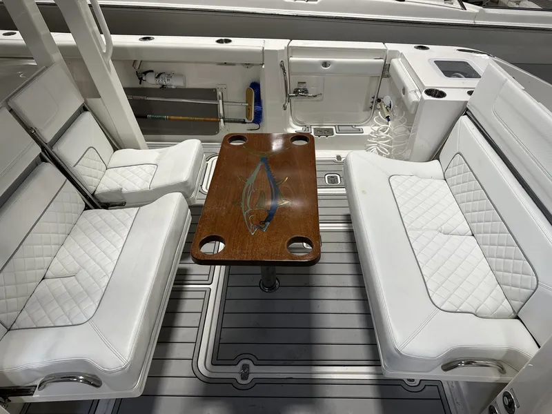 Slide: The Image of 2022 Pursuit S 358 Sport boat interior with white seating and wooden table. - 30