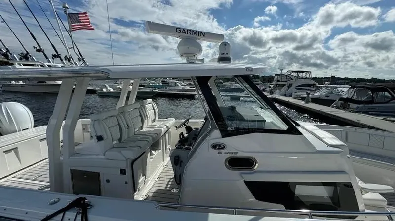Slide: The Image of 2022 Pursuit S 358 Sport boat docked at marina under cloudy sky. - 5