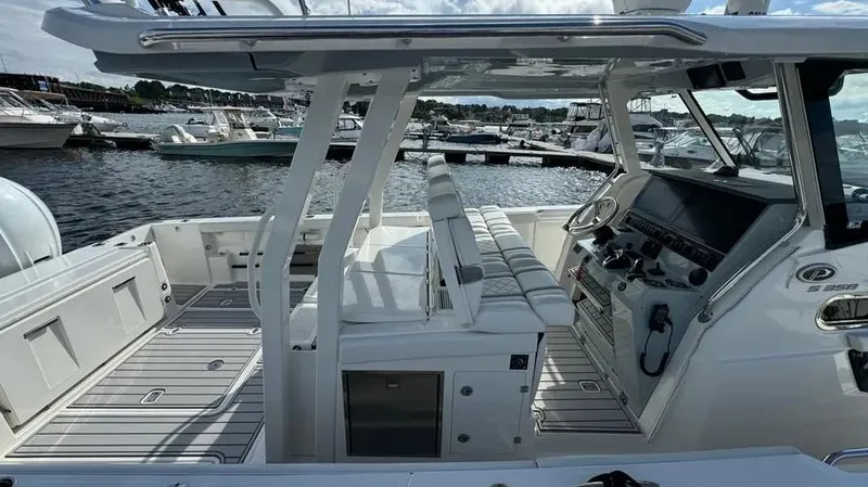 Slide: The Image of 2022 Pursuit S 358 Sport boat interior at marina, featuring sleek design and modern controls. - 6