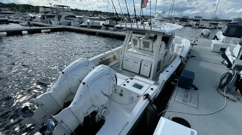 Slide: The Image of 2022 Pursuit S 358 Sport boat docked at marina with twin engines. - 8