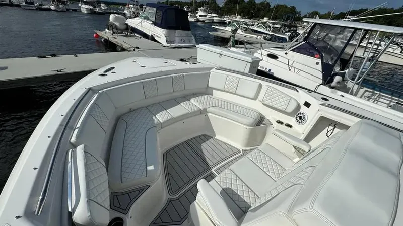 Slide: The Image of 2022 Pursuit S 358 Sport boat with luxurious seating at a marina. - 9