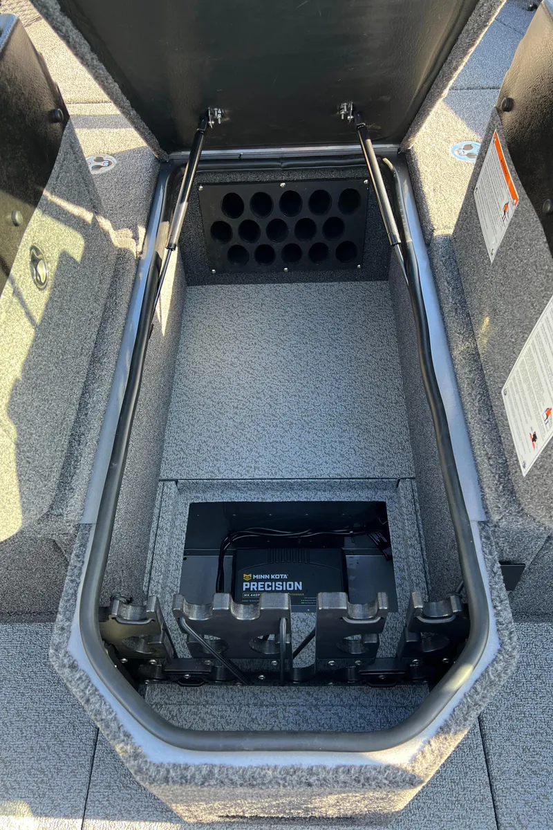 Slide: The Image of 2025 Lund 1875 Pro-V boat storage compartment with battery and rod holders. - 19