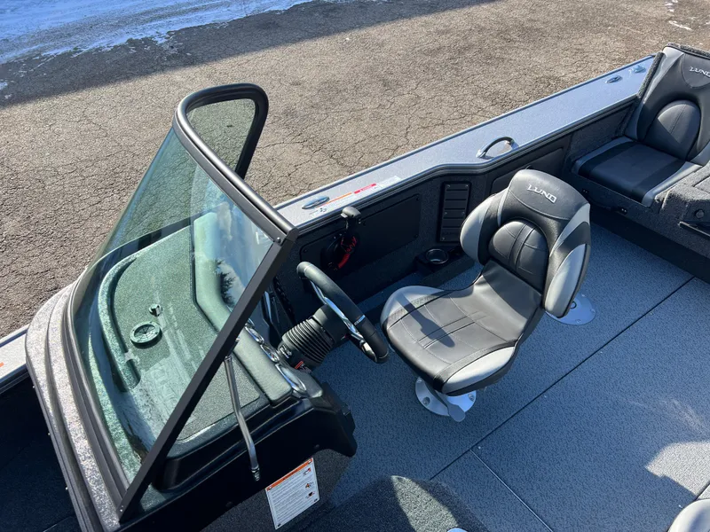 Slide: The Image of 2025 Lund 1875 Pro-V boat interior with steering wheel and seating. - 23