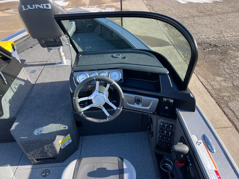 Slide: The Image of 2025 Lund 1875 Pro-V boat interior with steering wheel and dashboard controls. - 25