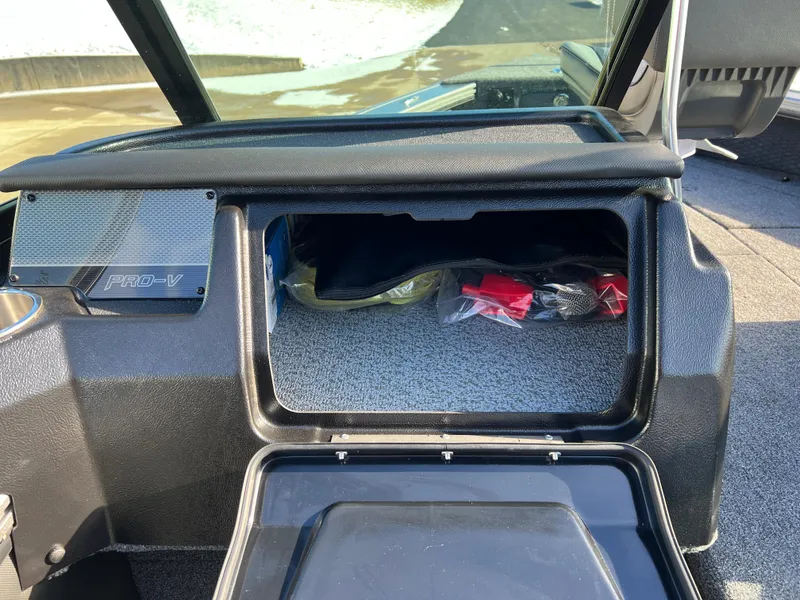 Slide: The Image of 2025 Lund 1875 Pro-V boat dashboard with open storage compartment. - 32
