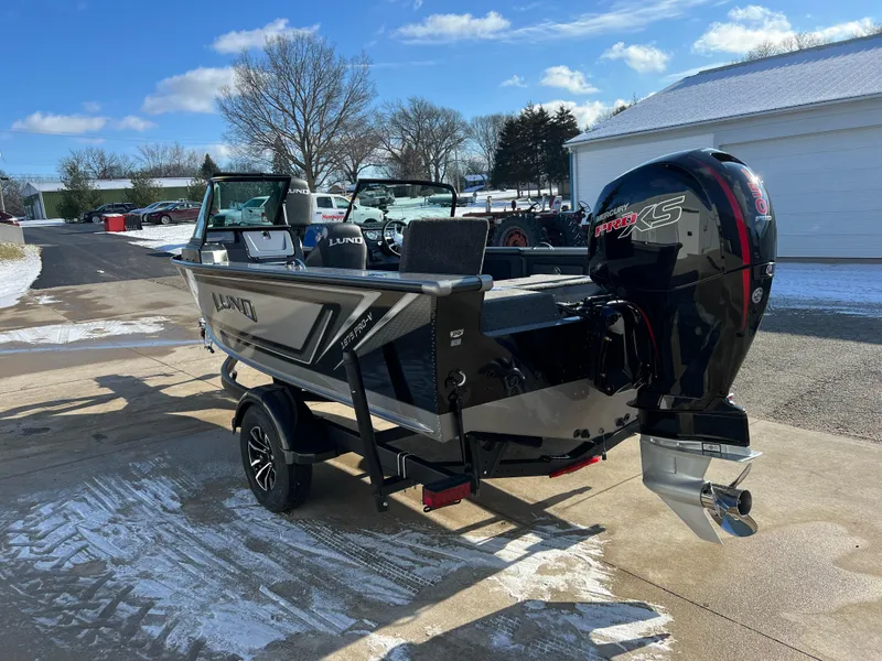 Slide: The Image of 2025 Lund 1875 Pro-V boat with powerful outboard motor in snowy driveway. - 4