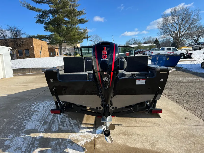 Slide: The Image of 2025 Lund 1875 Pro-V boat with 150 HP engine, parked outdoors on a sunny day. - 5