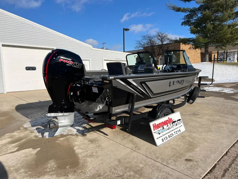 Slide: The Image of 2025 Lund 1875 Pro-V boat with powerful outboard motor in driveway. - 6