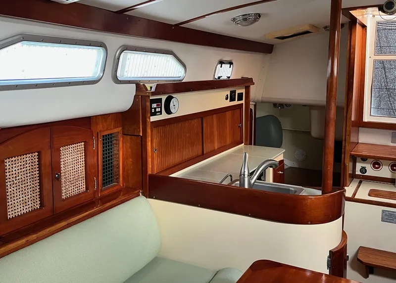 Slide: The Image of Interior of 2006 Shannon Shoalsailer sailboat with wood finish and compact kitchen area. - 11