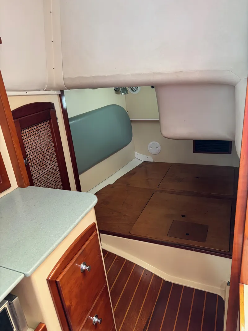 Slide: The Image of 2006 Shannon Shoalsailer cabin interior with wooden flooring and compact sleeping area. - 14