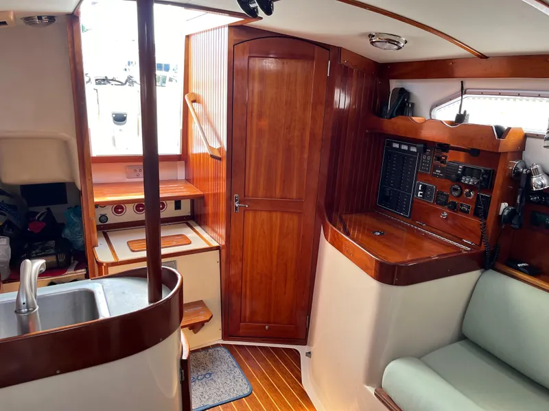 Slide: The Image of Interior of 2006 Shannon Shoalsailer, featuring wood paneling, kitchenette, and navigation controls. - 19