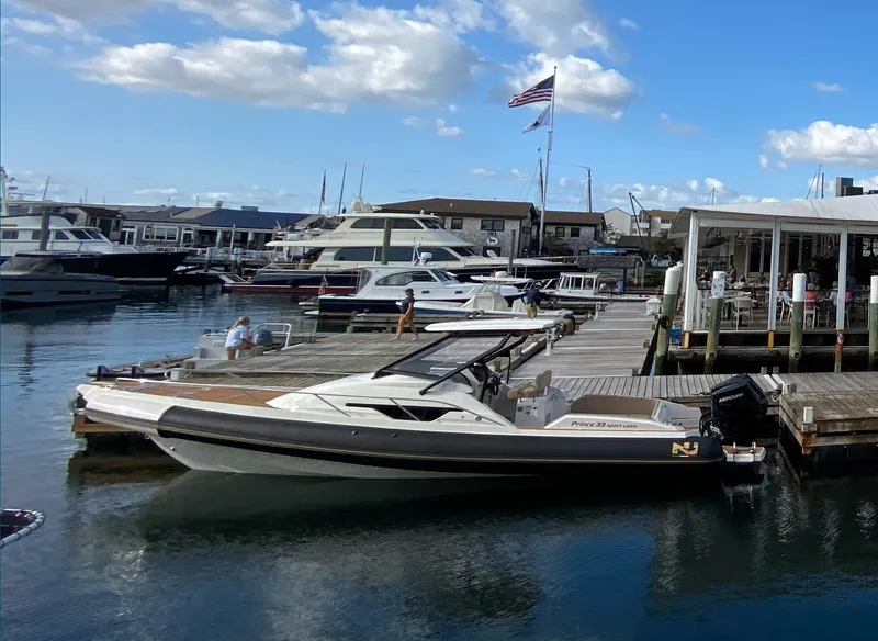 The Image of Nuova Jolly Prince 33 SPORT CABIN 2025 docked at a marina under a blue sky. - 2