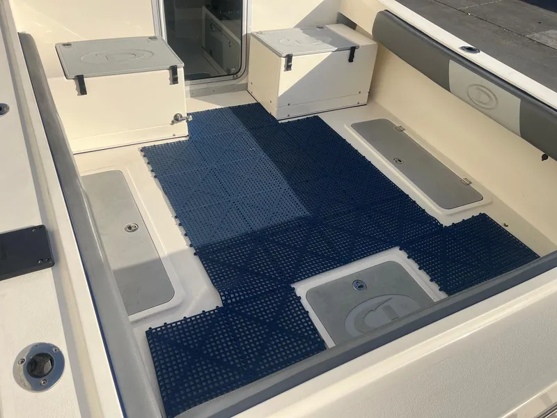 Slide: The Image of 2023 Defiance Admiral 220 EX boat interior with blue mat and storage compartments. - 10