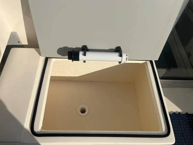 Slide: The Image of 2023 Defiance Admiral 220 EX boat storage compartment with open lid and drain. - 12