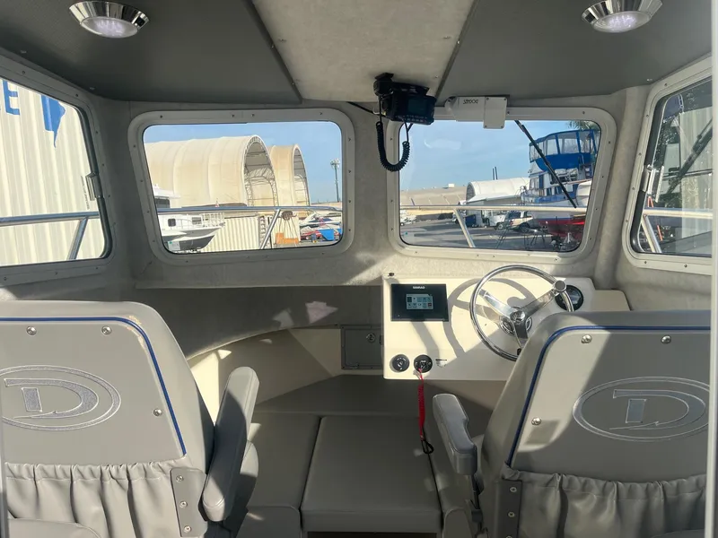Slide: The Image of Interior of 2023 Defiance Admiral 220 EX boat, featuring helm and seating. - 13