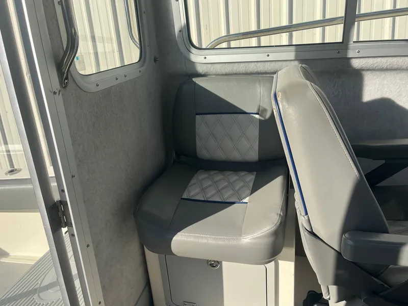 Slide: The Image of 2023 Defiance Admiral 220 EX interior with gray seating and window view. - 17