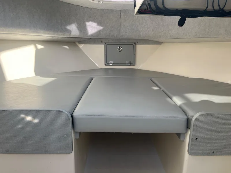 Slide: The Image of 2023 Defiance Admiral 220 EX boat interior with cushioned seating and storage compartment. - 19
