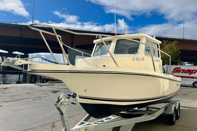 Slide: The Image of 2023 Defiance Admiral 220 EX boat on trailer under bridge, clear sky background. - 4