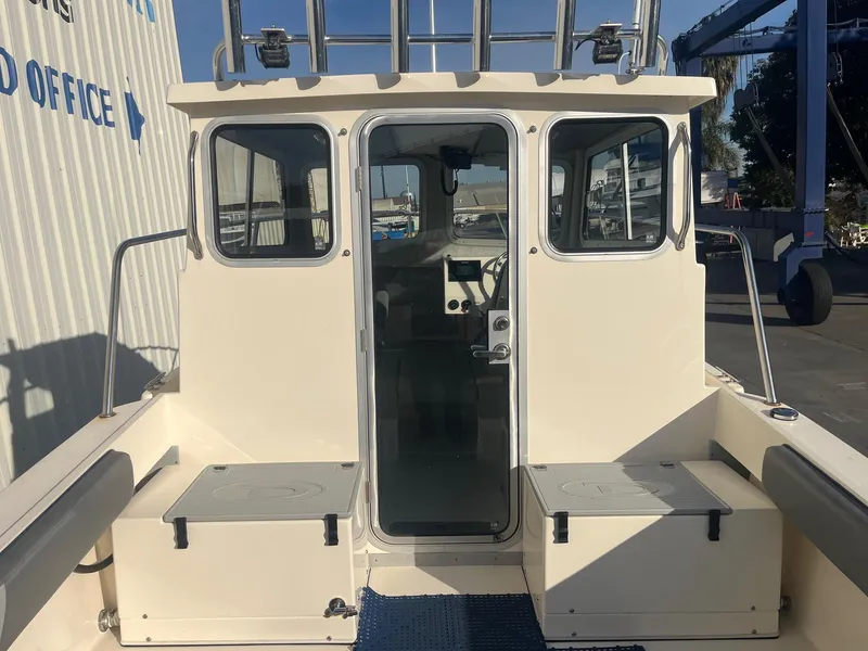 Slide: The Image of 2023 Defiance Admiral 220 EX boat, rear view, docked near office building. - 8