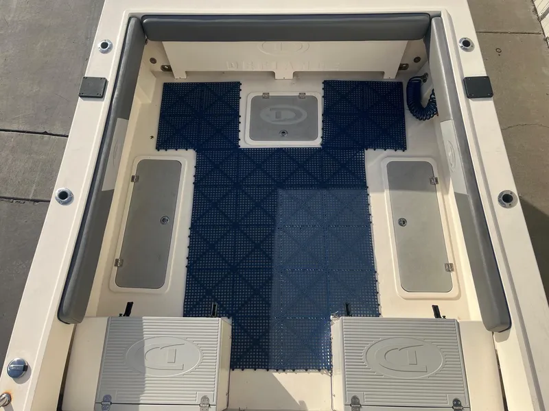 Slide: The Image of 2023 Defiance Admiral 220 EX boat interior with blue flooring and storage compartments. - 9