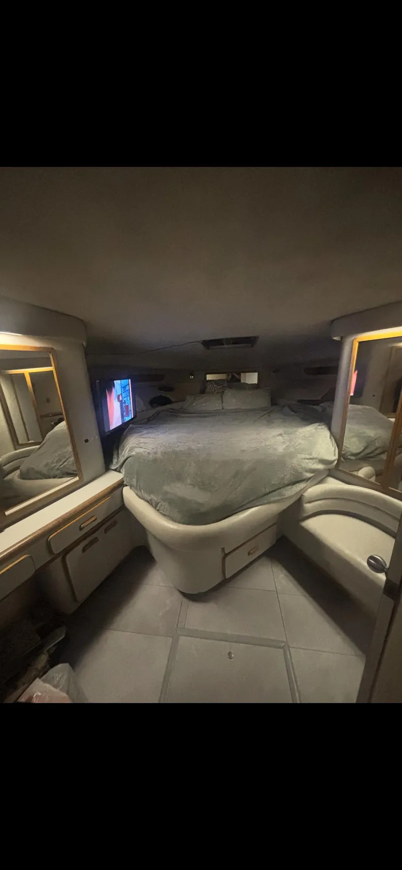 Slide: The Image of Interior of 1991 Sea Ray Sun Dancer 480 Express yacht, featuring a cozy cabin with a bed. - 16