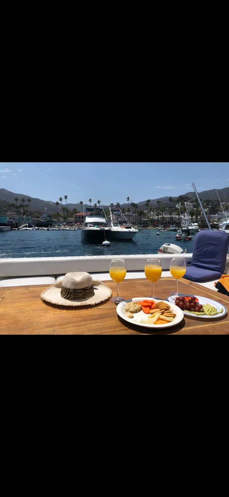 Slide: The Image of 1991 Sea Ray Sun Dancer 480 Express with breakfast and drinks on deck, scenic harbor view. - 18