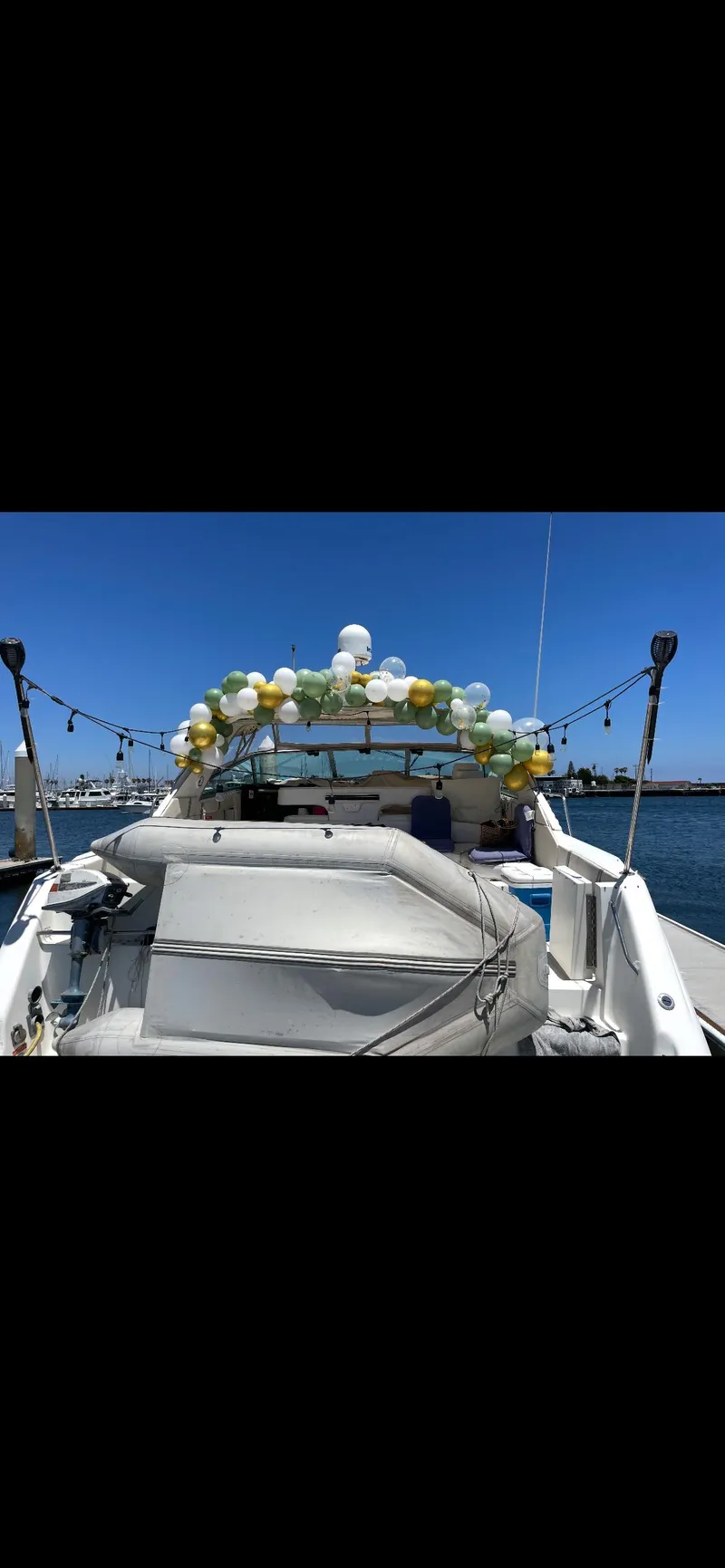 Slide: The Image of 1991 Sea Ray Sun Dancer 480 Express decorated with balloons on a sunny day. - 23