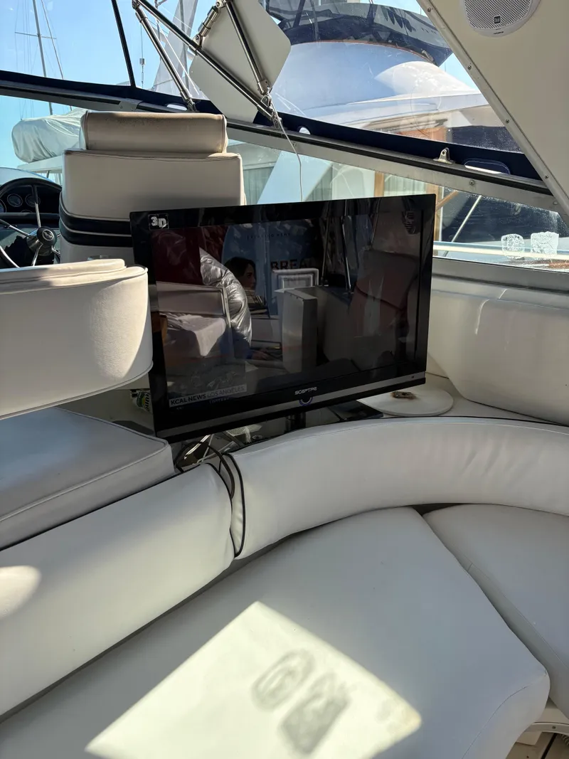 Slide: The Image of Interior of 1991 Sea Ray Sun Dancer 480 Express with TV and white seating. - 25