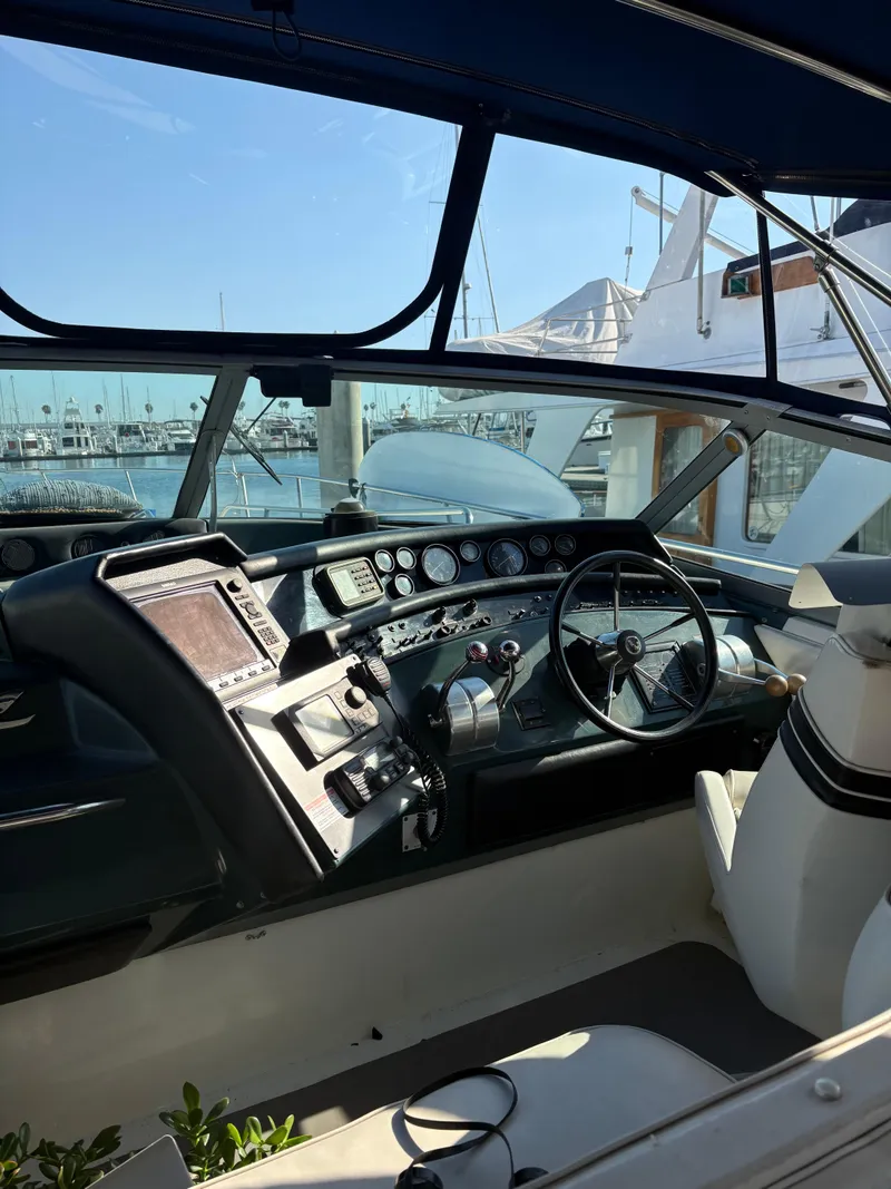 Slide: The Image of 1991 Sea Ray Sun Dancer 480 Express cockpit with steering wheel and control panel. - 27